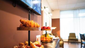 A breakfast buffet with pastries and fruits.