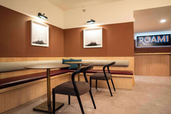 A restaurant with a booth seating area, two tables, and chairs.