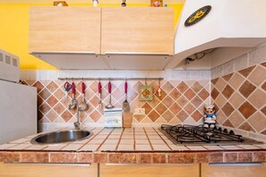 Una cocina con un lavamanos, estufa y armarios.
