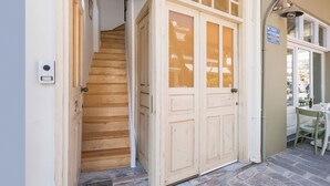Un escalier en bois mène à un ensemble de portes doubles dotées de panneaux en verre dépoli.