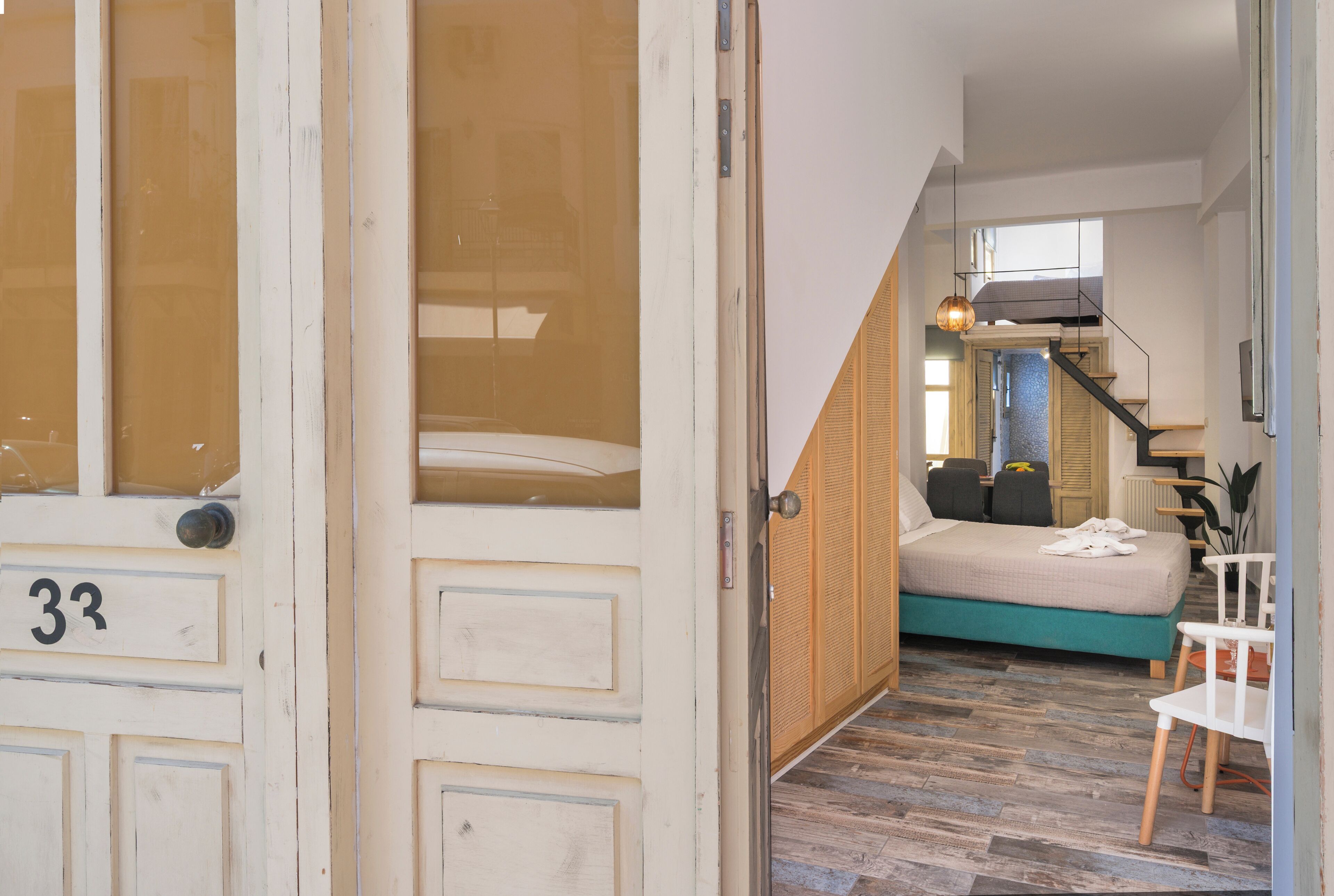 Una habitación con una cama, una silla y una escalera que sube a otro nivel.