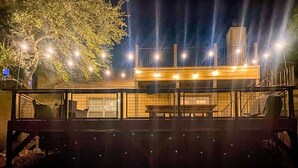 Un bâtiment moderne doté d’une façade en verre, d’un espace extérieur aménagé pour s’asseoir et d’un escalier menant à un niveau supérieur.