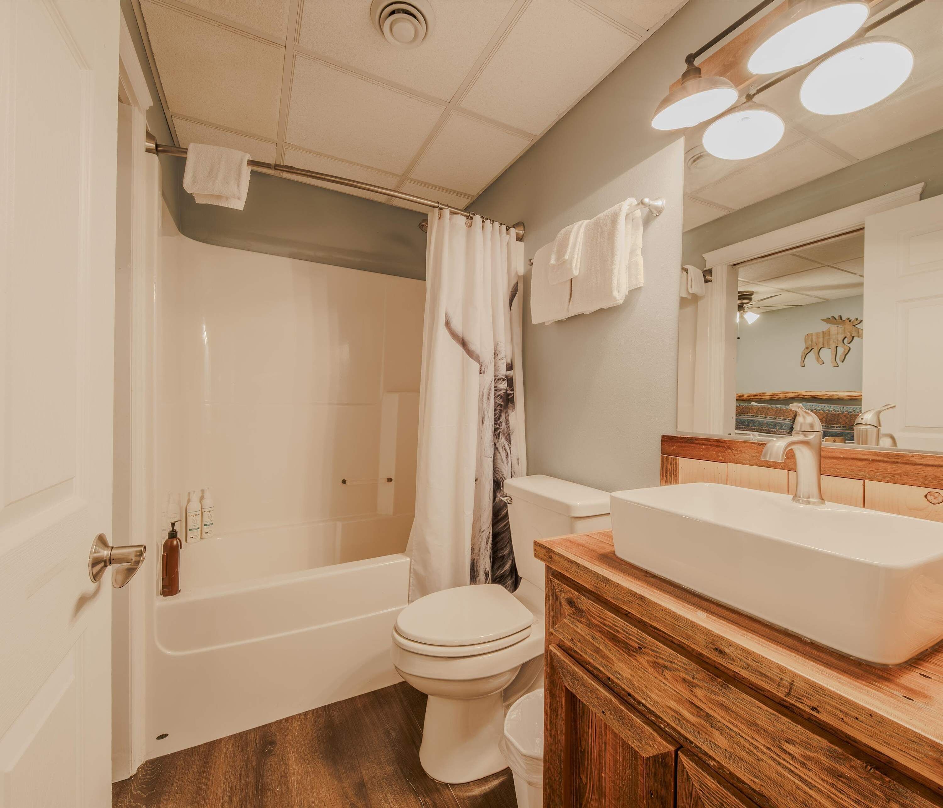 A bathroom with a bathtub, toilet, and vanity with a sink.