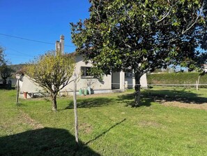 A house with a well-maintained lawn, a tree, and a chimney. - L'ECRIN DE JOSELIA, 60m2 renovated family home in Périgord Vert (QUINSAC)