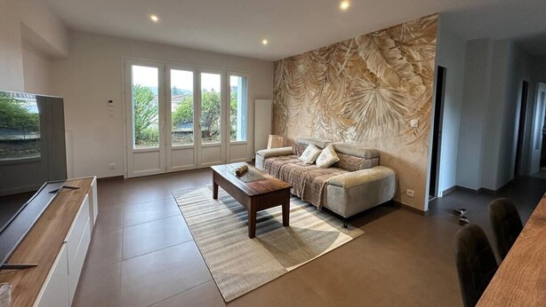 A modern living room with a sofa, coffee table, and a large window. - L'ECRIN DE JOSELIA, 60m2 renovated family home in Périgord Vert (QUINSAC)
