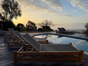 A wooden deck with lounge chairs and a swimming pool. - Contemporary sheepfold with heated swimming pool (Sotta)
