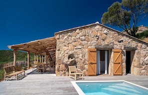 A stone building with a pool, wooden shutters, and outdoor seating. - Contemporary sheepfold with heated swimming pool (Sotta)