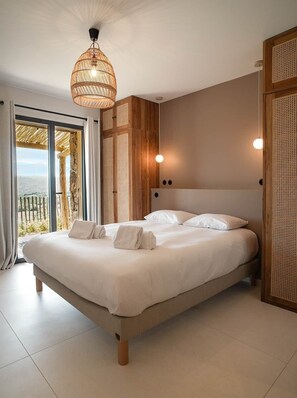 A bedroom with a large bed, a woven ceiling light, and a view of the outdoors. - Contemporary sheepfold with heated swimming pool (Sotta)