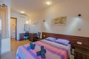 Une chambre d’hôtel avec un lit, un bureau, une chaise et une œuvre d’art au mur.