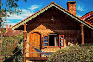 Una casa de ladrillo rústica con puerta de madera y un pequeño porche.
