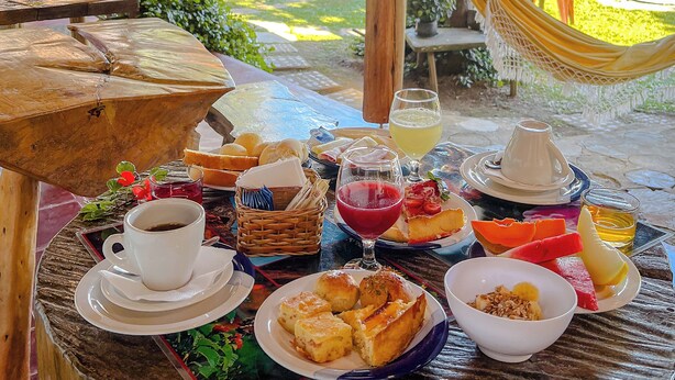 Ein Tisch ist gedeckt mit Frühstücksleckereien, darunter Brot, Obst und Getränke.