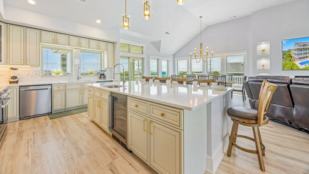 A spacious kitchen with a large island, modern appliances, and pendant lighting. - New Soundside Dog Friendly Avon Retreat with Pool, Hot Tub, Game Room, Theater (Salvo)