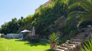 A well-maintained lawn with outdoor furniture, a stone staircase, and lush greenery. - Villa baie des anges (Nice)