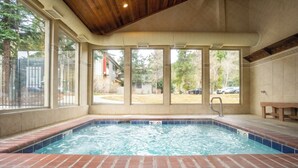 A hot tub with a view of a backyard, a wooden ceiling, and a tiled floor. - Flying Dutchman Slopeside Condo: Pool/Hot Tub Access, On Shuttle Route (Keystone)