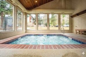 A hot tub with a view of a backyard, a wooden ceiling, and a tiled floor. - Flying Dutchman Slopeside Condo: Pool/Hot Tub Access, On Shuttle Route (Keystone)