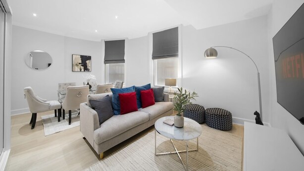 A modern living room with a sofa, chairs, a coffee table, and a TV. - Hyde Park 2 Bed Apt (London)