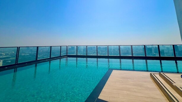 Ein Pool mit Infinity-Kante und freiem Blick auf die Stadtlandschaft.