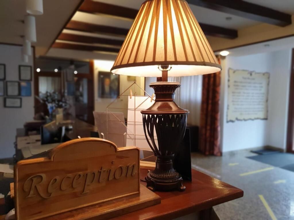 Un mostrador de recepción con una lámpara y un cartel que dice 'Reception'.
