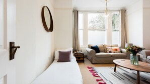Ein Zimmer mit einem Bett, einem Schlafsofa, einem Couchtisch und einem fenster mit Vorhängen.