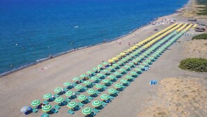 A beach with rows of sun umbrellas and beach chairs. - Hotiday Montalto Marina (Montalto di Castro)