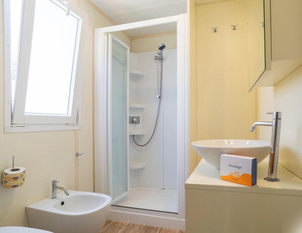 A bathroom with a shower, sink, and toilet.