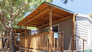 A wooden RV with a porch, stone exterior, and a 'hotider' sign. - Hotiday Montalto Marina (Montalto di Castro)