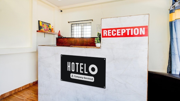 A reception desk with a sign indicating it is a company-serviced hotel. - Hotel O Snist University Hyderabad (Hyderabad)