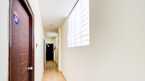 A hallway with a wooden door marked "201" and a window on the right. - Hotel O Snist University Hyderabad (Hyderabad)