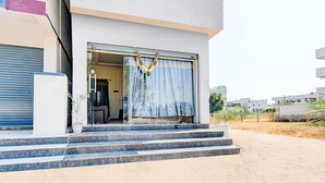 A modern building with a glass door and steps leading to a covered entrance. - Hotel O Snist University Hyderabad (Hyderabad)