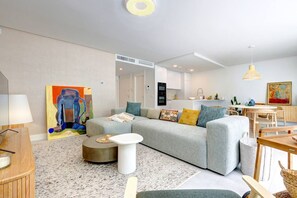 A modern living room with a grey sofa, a round coffee table, and a painting on the wall. - Luxury vacation with a terrace and private pool (Marbella)