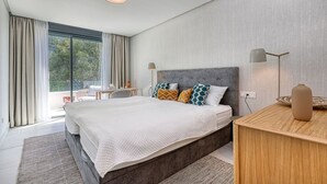 A modern bedroom with a large bed, a desk, and a view of the outdoors. - Luxury getaway with terrace and private pool (Marbella)