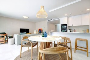 A modern living room with a round dining table, wicker chairs, a sofa, and a television. - Luxury vacation with a terrace and private pool (Marbella)