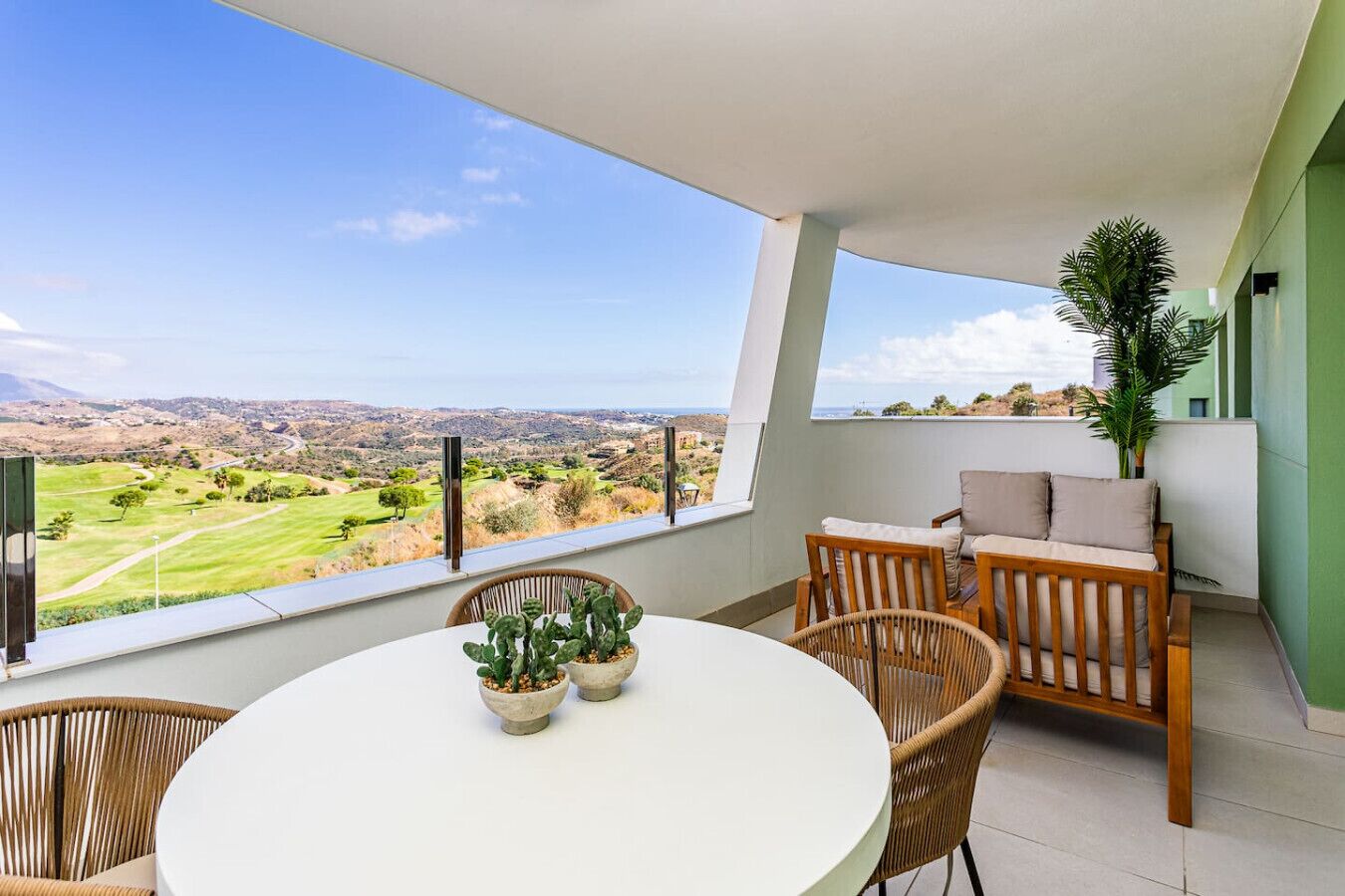 Ein Balkon mit Blick auf einen Golfplatz und sanfte Hügel in der Ferne.