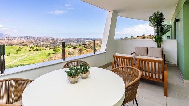 A balcony with a view of a golf course and distant hills. - Ipanema 2 BR apartment with views (Mijas)