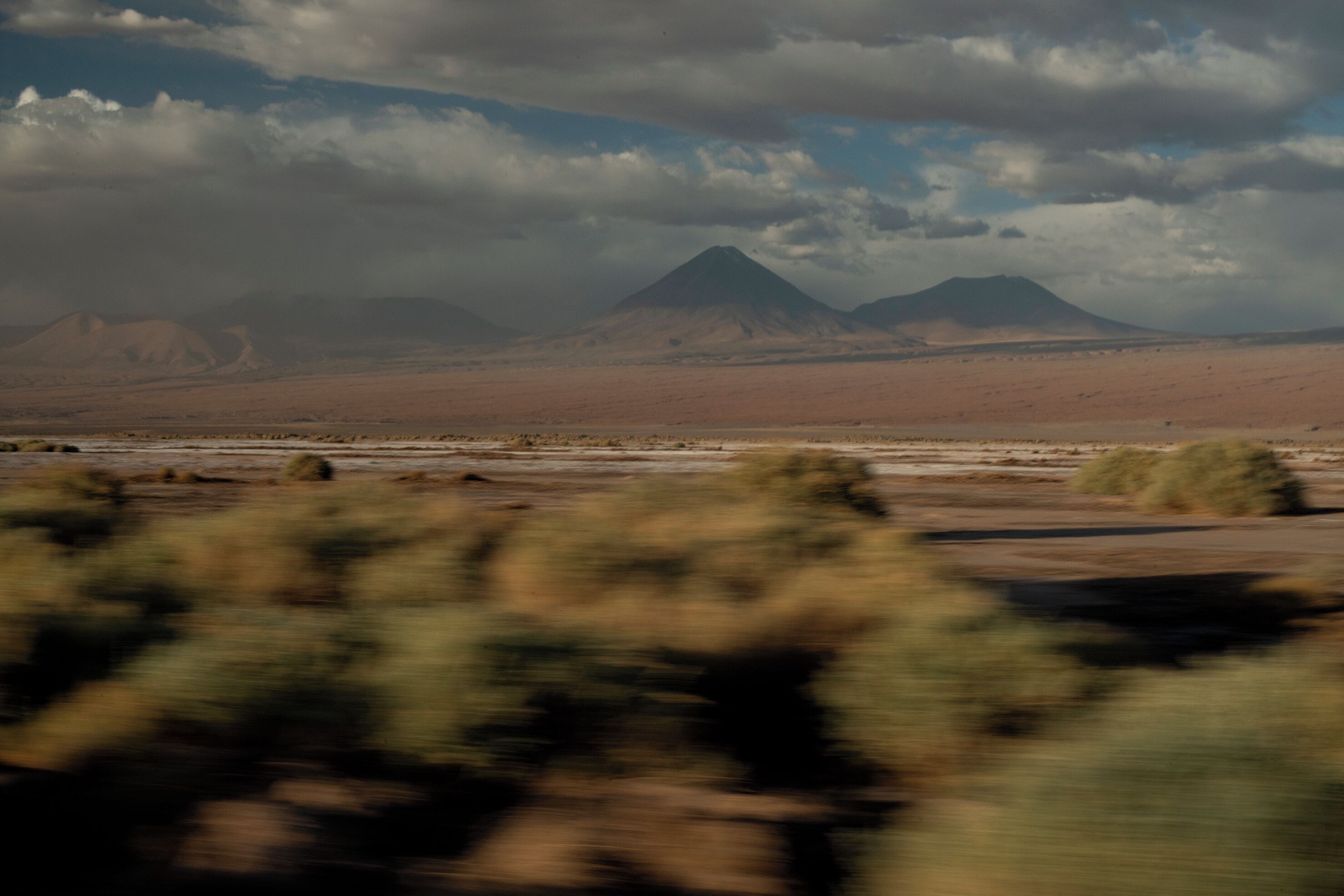 A desert landscape with mountains in the background.