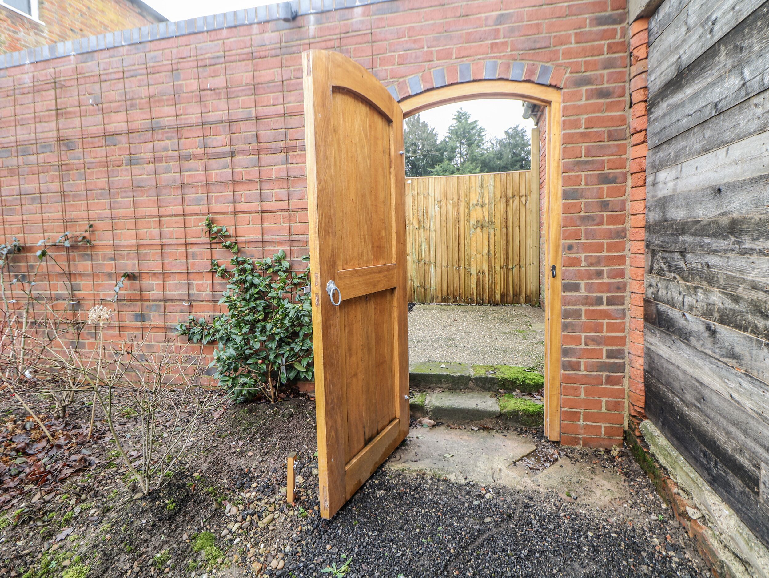 A wooden door leading to a gravel path.