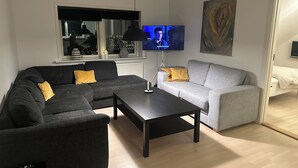 A modern living room with a sectional sofa, a coffee table, and a TV.