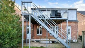 A building with a metal staircase leading to a balcony.