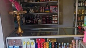 Een winkel met schappen vol diverse producten, waaronder flessen, dozen en decoratieve objecten.