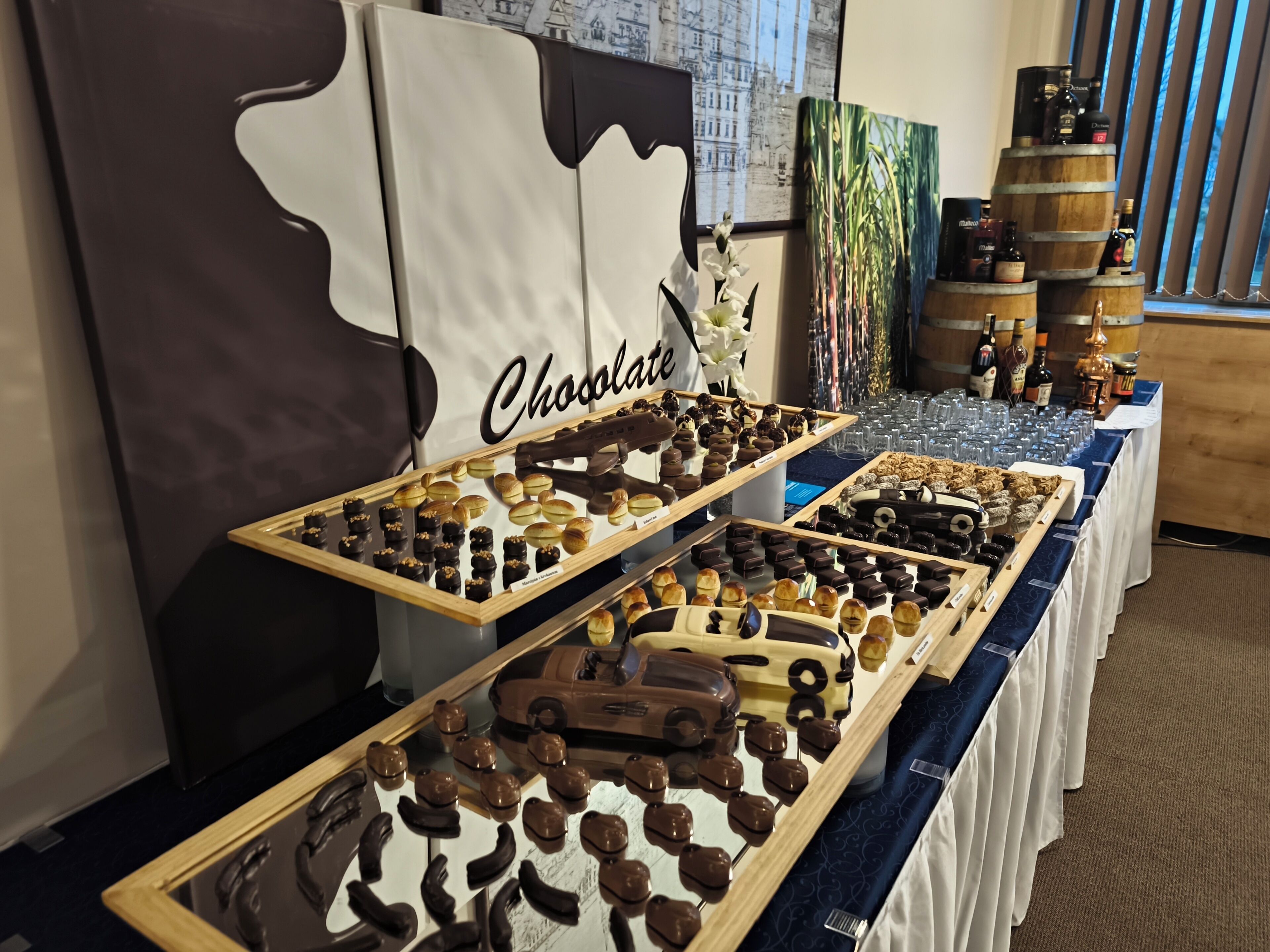 A chocolate display with various confections and a backdrop with a 'Chocolate' sign.