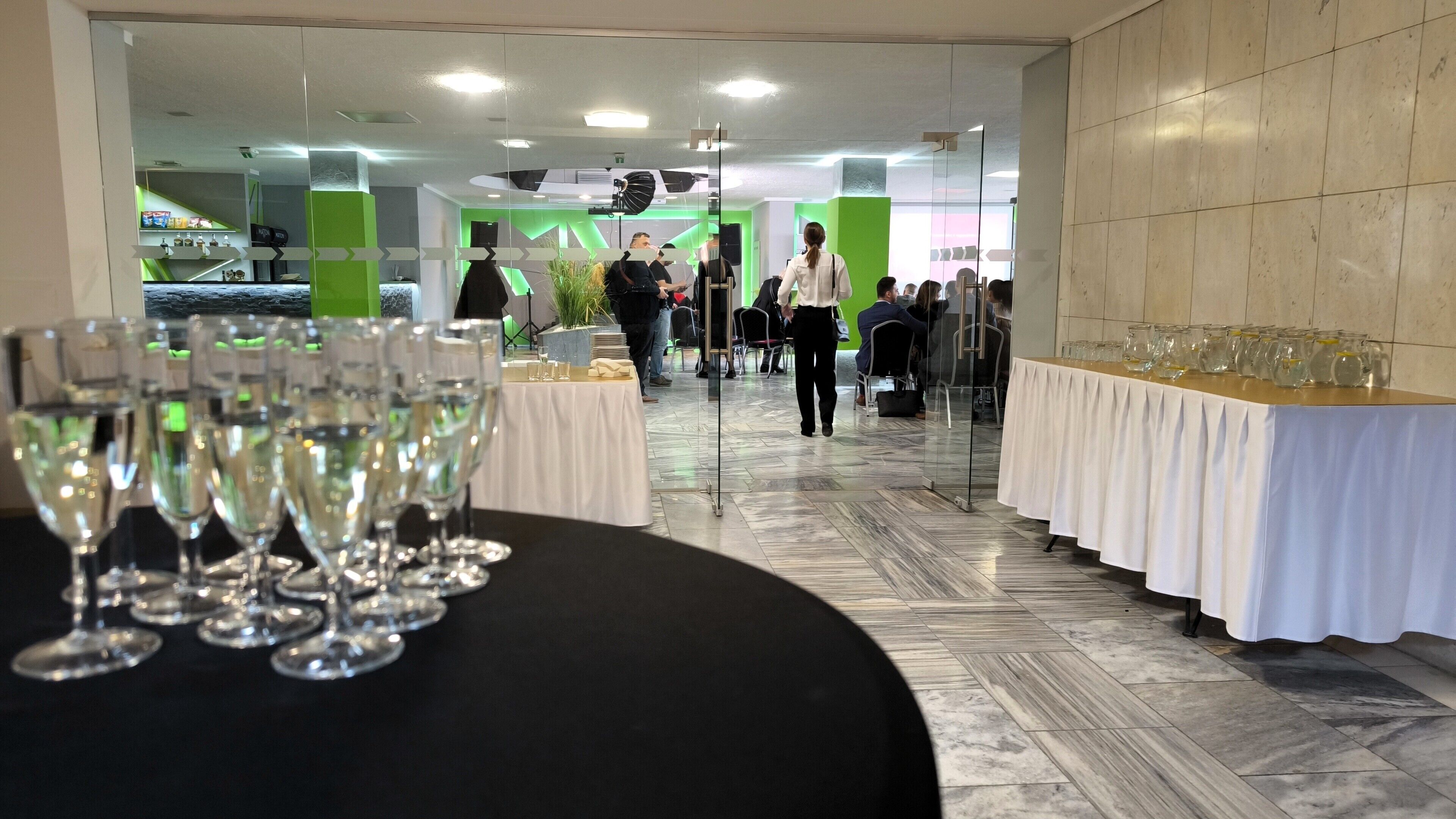 Une salle de conférence équipée de tables, de chaises et d’une cloison en verre.