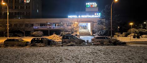 A hotel with a sign reading 'HOTEL & RESTAURANT' at night.