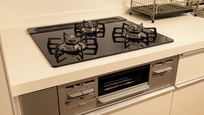 Una cocina con estufa negra, horno empotrado y microondas.