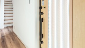 Una puerta de madera con un panel de vidrio esmerilado, un picaporte de metal y una cerradura.