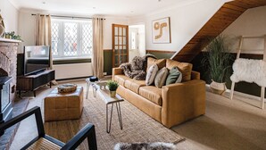 Una sala de estar acogedora con un sofá, un televisor y una chimenea.
