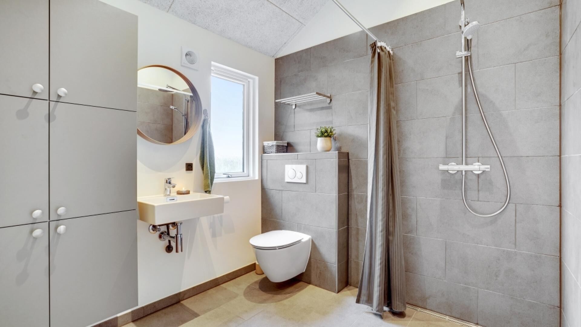 Une salle de bain moderne équipée d’une douche, de toilettes et d’un lavabo.