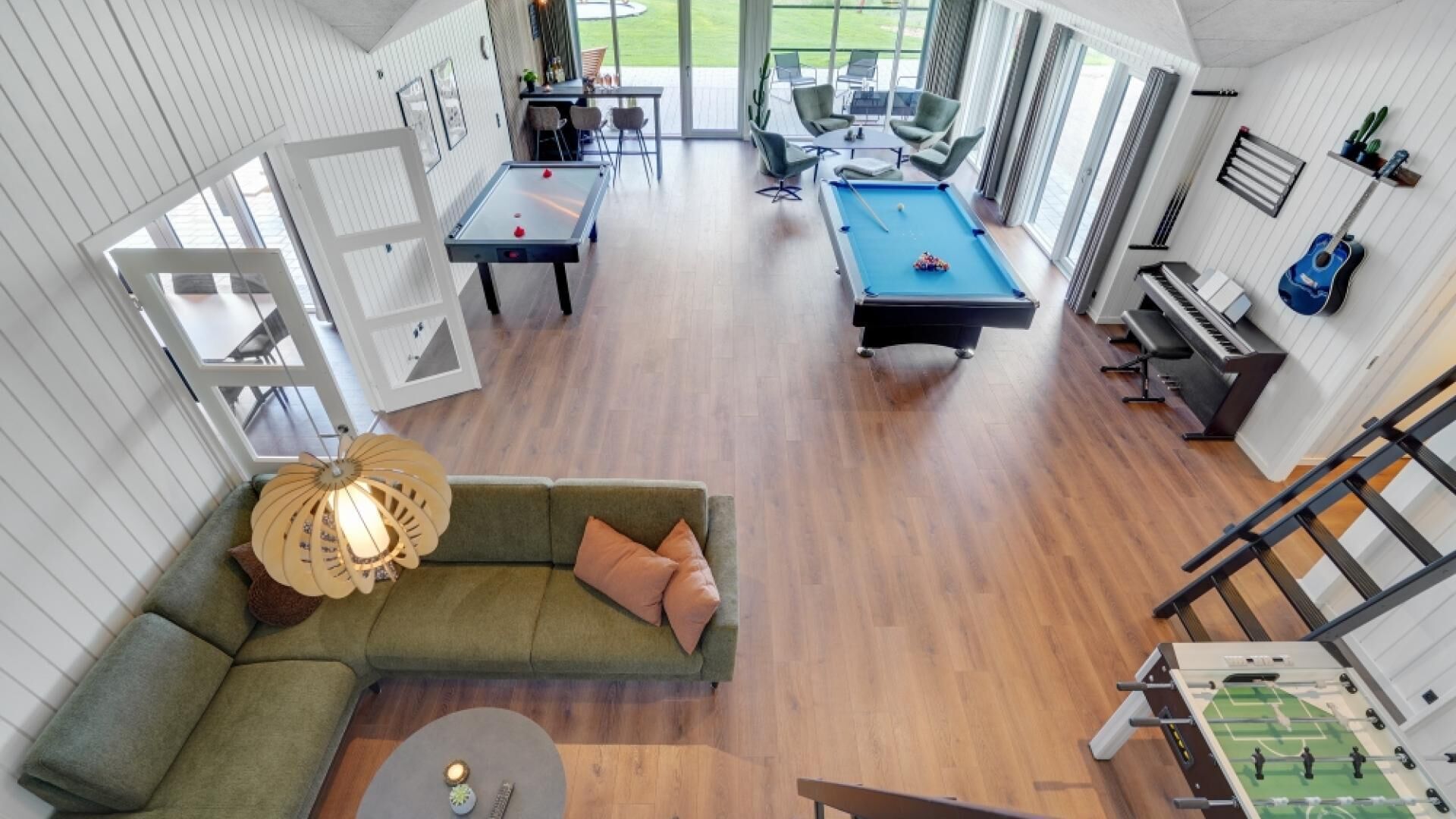 A spacious living area with a pool table, a sofa, and a ping pong table.
