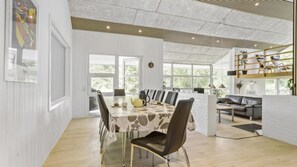 Een moderne eethoek met een tafel voor vier personen, omringd door stoelen.