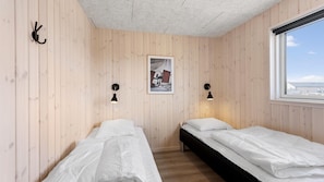 A room with two beds, wooden walls, a framed picture, and a window with a view. - VillaVilla 917 - Skåstrup Strand, Fyn og øer (Bogense)