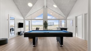 A pool table in a room with large windows and a view of the outdoors. - VillaVilla 917 - Skåstrup Strand, Fyn og øer (Bogense)